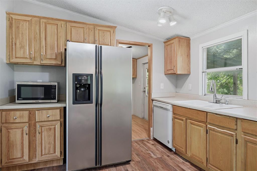 150 Gilbreath Road Sadler, TX 76264 - Photo 11 of 34 a kitchen with cabinets stainless steel appliances a sink and a window