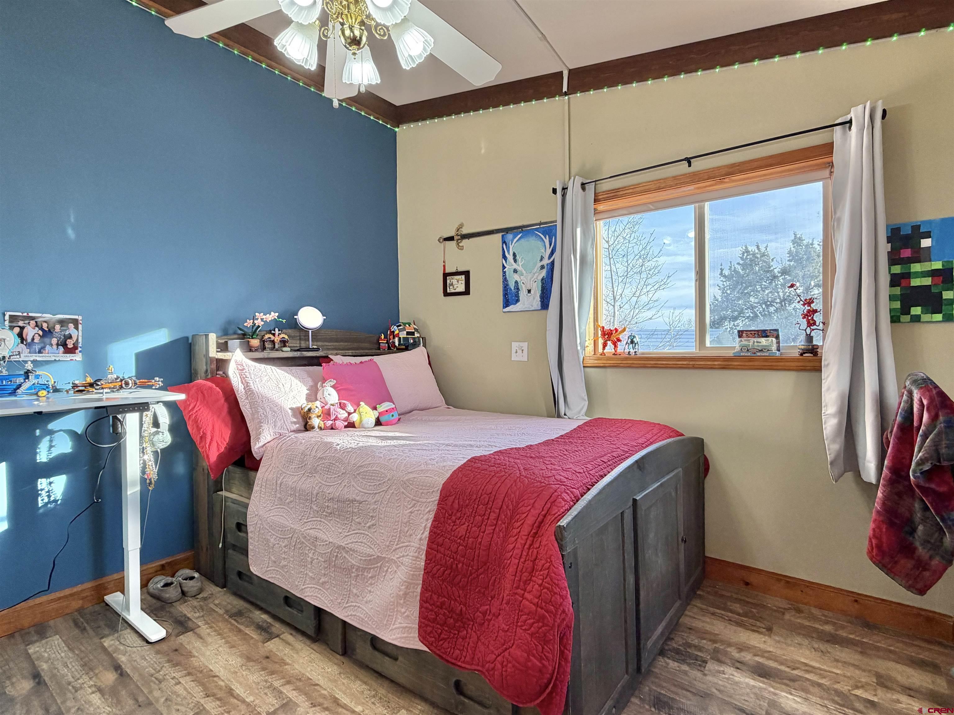 18377 Highway 65 Cedaredge, CO 81413 - Photo 17 of 45 a bedroom with a bed and a chandelier