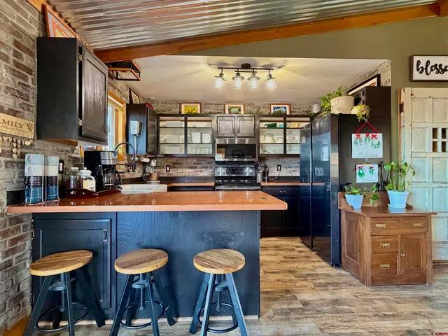 a kitchen with stainless steel appliances granite countertop a sink and a refrigerator