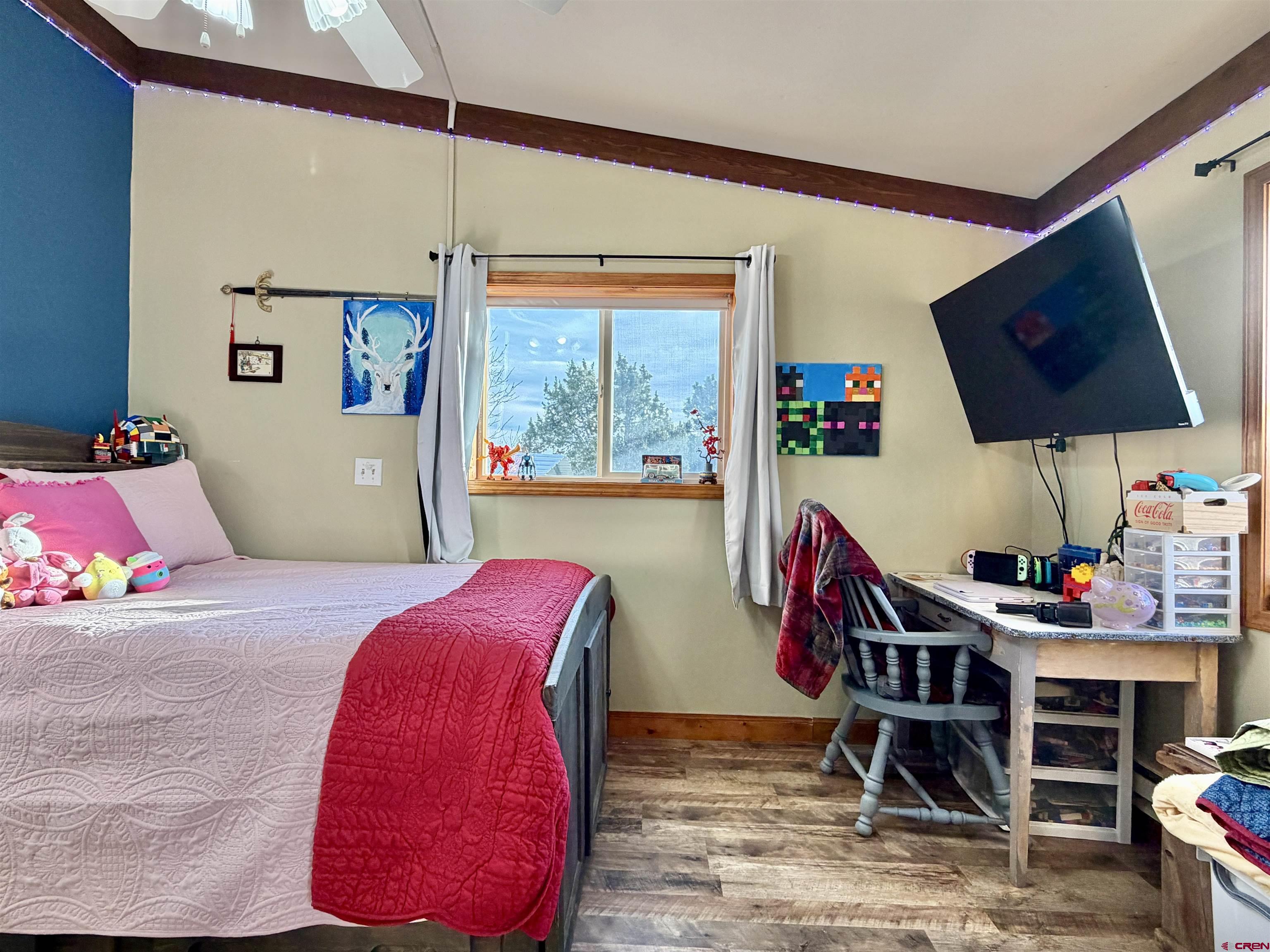 18377 Highway 65 Cedaredge, CO 81413 - Photo 18 of 45 a bedroom with furniture and a flat screen tv