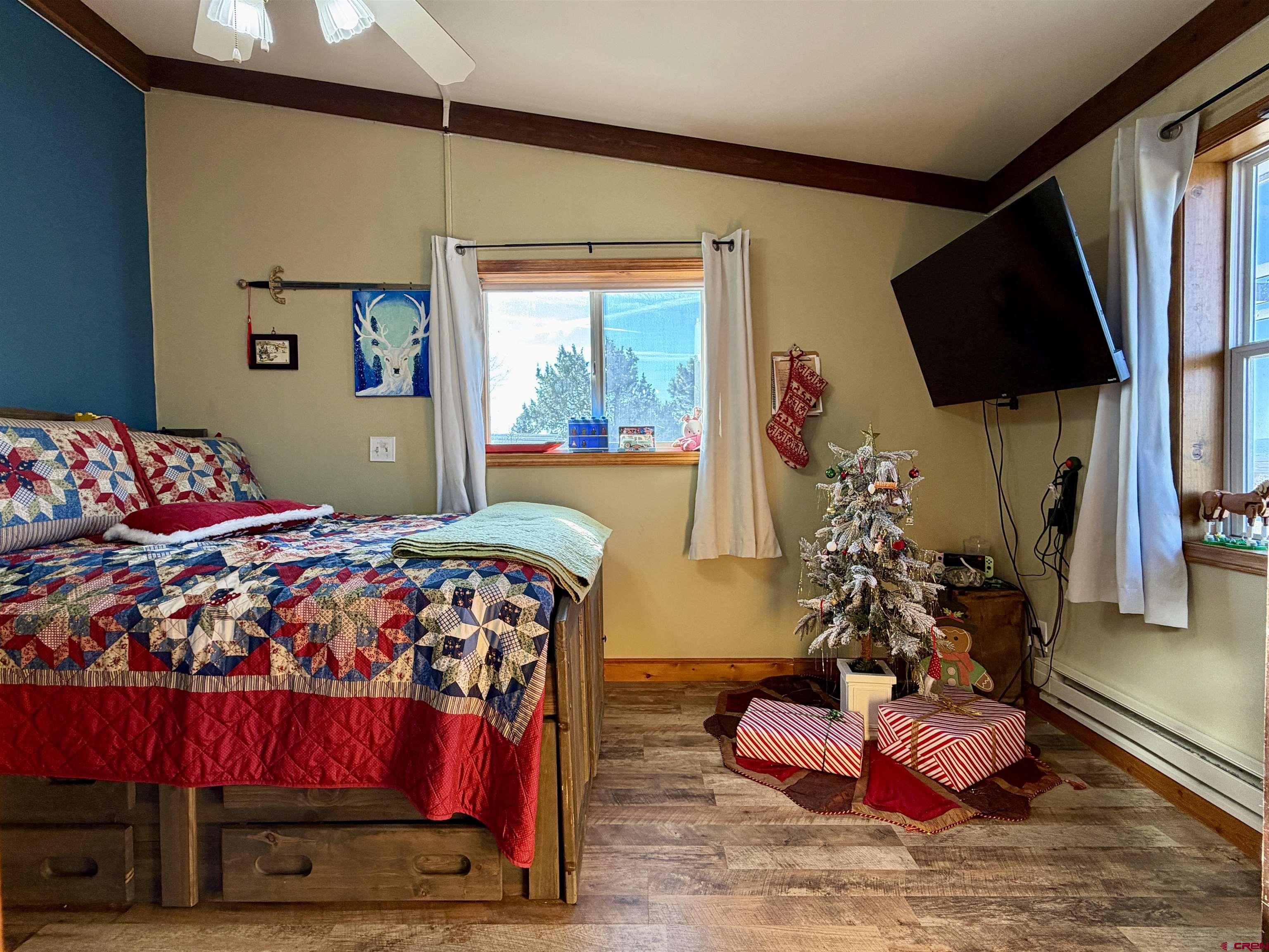 18377 Highway 65 Cedaredge, CO 81413 - Photo 27 of 45 a bedroom with a bed window and flat screen tv