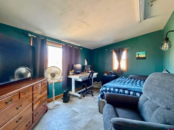 a large bed sitting in a bedroom next to a window