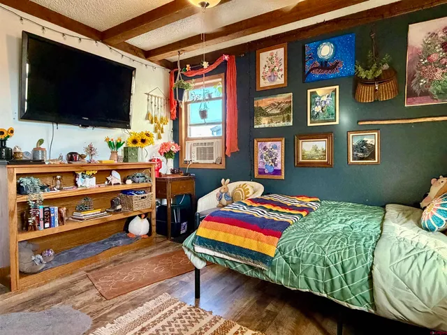 a bedroom with a bed and a flat screen tv