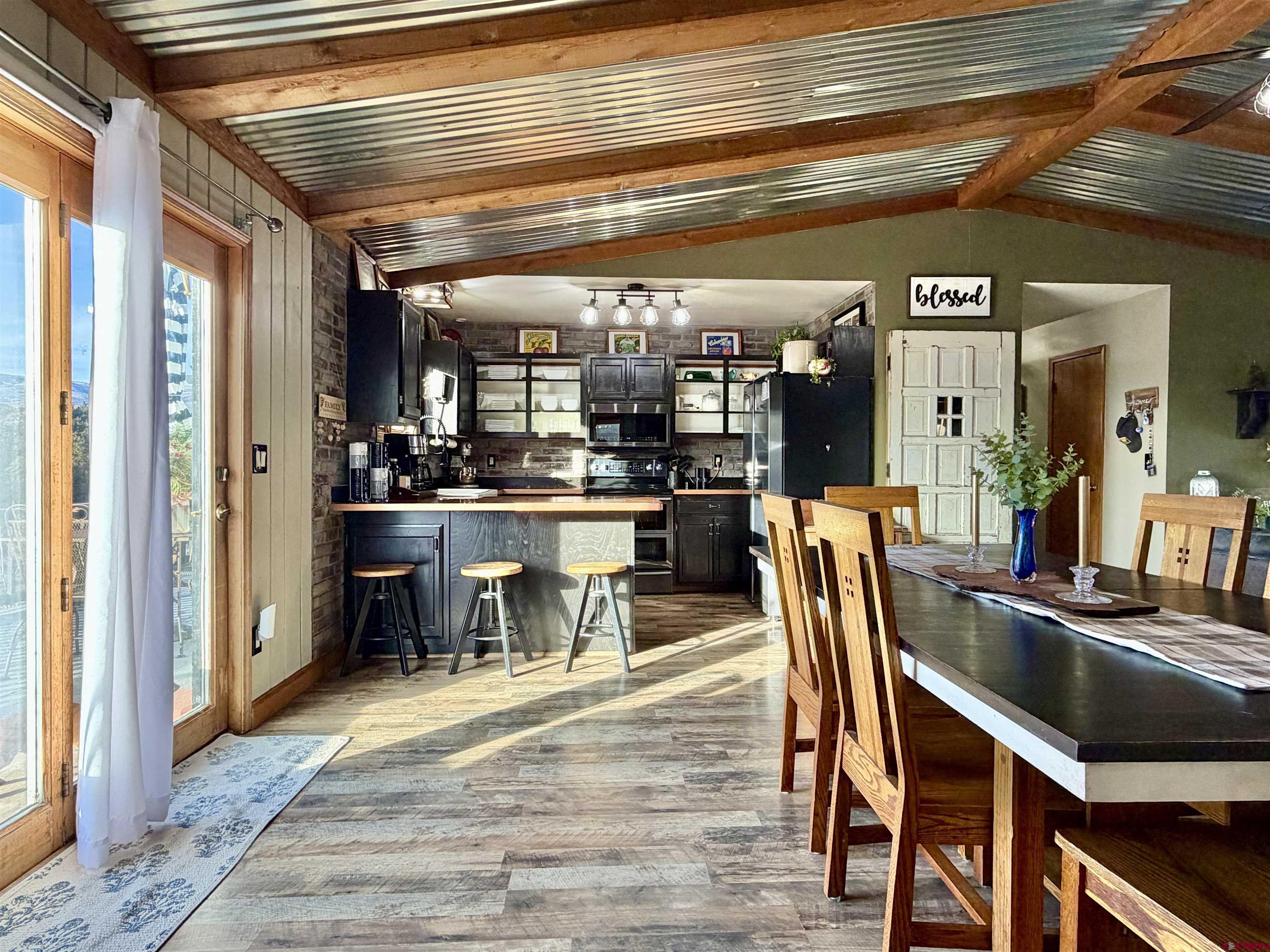 18377 Highway 65 Cedaredge, CO 81413 - Photo 6 of 45 a dining room with stainless steel appliances kitchen island granite countertop a table chairs and a chandelier