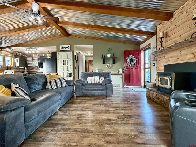 a dining room with stainless steel appliances kitchen island granite countertop a table chairs and a chandelier