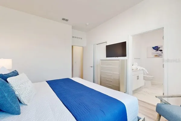 a bedroom with a bed and a flat screen tv