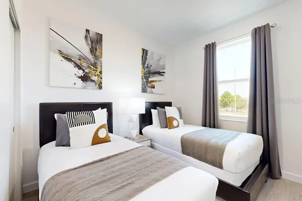 a bedroom with two beds and a large window