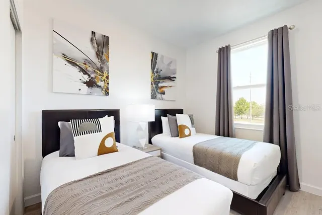 a bedroom with two beds and a large window