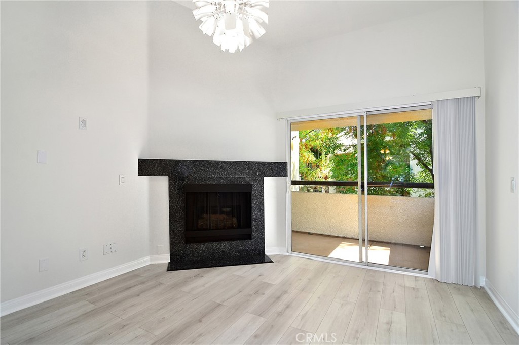 5510 Owensmouth Avenue, Unit 301 Woodland Hills, CA 91367 - Photo 3 of 22 an empty room with wooden floor fireplace and windows