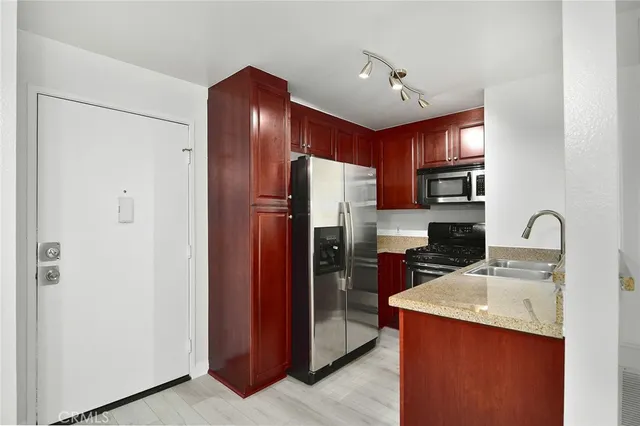 a kitchen with stainless steel appliances granite countertop a refrigerator a sink and a stove