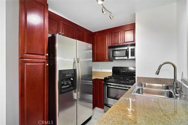 a kitchen with granite countertop a refrigerator and a sink