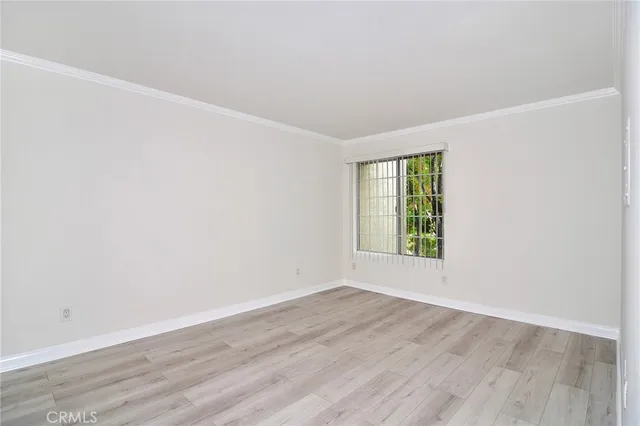 an empty room with wooden floor and window