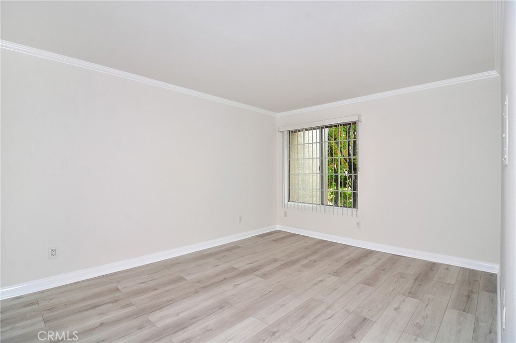 5510 Owensmouth Avenue, Unit 301 Woodland Hills, CA 91367 - Photo 6 of 22 an empty room with wooden floor and window