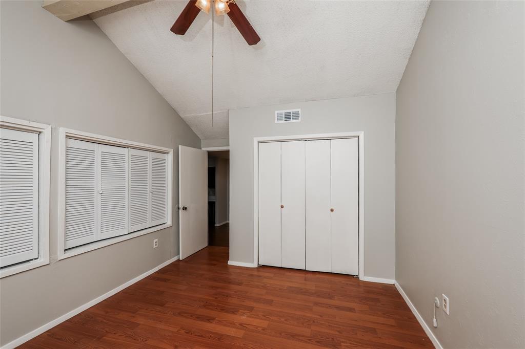 9696 Walnut Street, Unit 1216 Dallas, TX 75243 - Photo 6 of 16 Vaulted ceiling featuring a ceiling fan, light gray wall paint, wood-finish flooring, two windows with louvered shutters, and a bi-fold door closet
