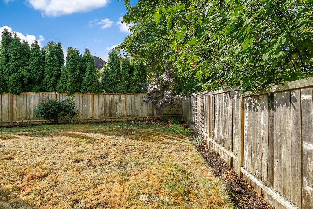 22526 14th Place West Bothell, WA 98021 - Photo 25 of 25 a view of a backyard with large trees and wooden fence