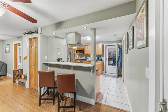 a kitchen with stainless steel appliances a dining table chairs and wooden floor