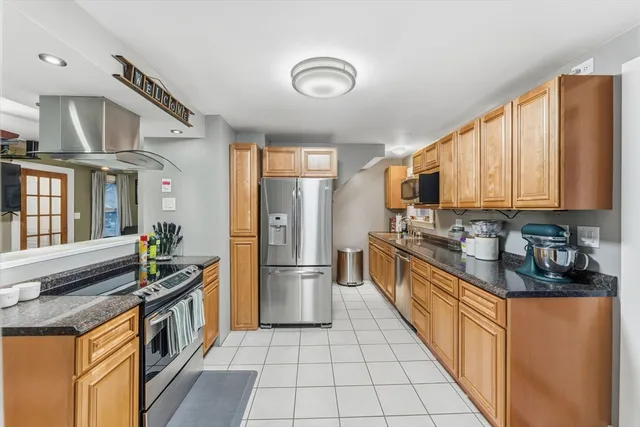 a kitchen with stainless steel appliances granite countertop a refrigerator a stove and a sink