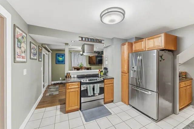a kitchen with stainless steel appliances granite countertop a refrigerator a stove and a sink