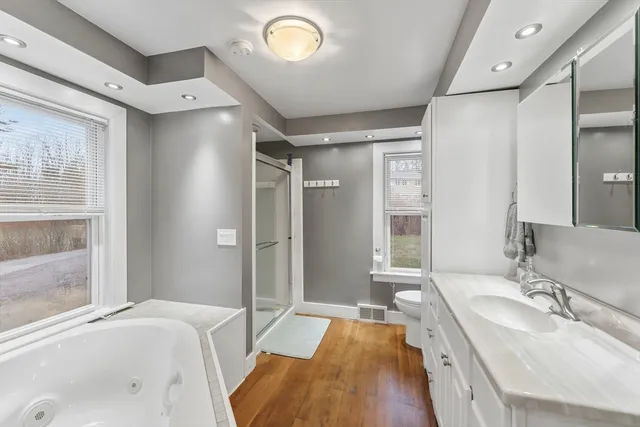 a spacious bathroom with a tub sink and mirror