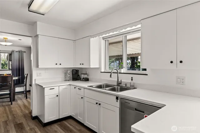 a kitchen with stainless steel appliances a table and chairs in it