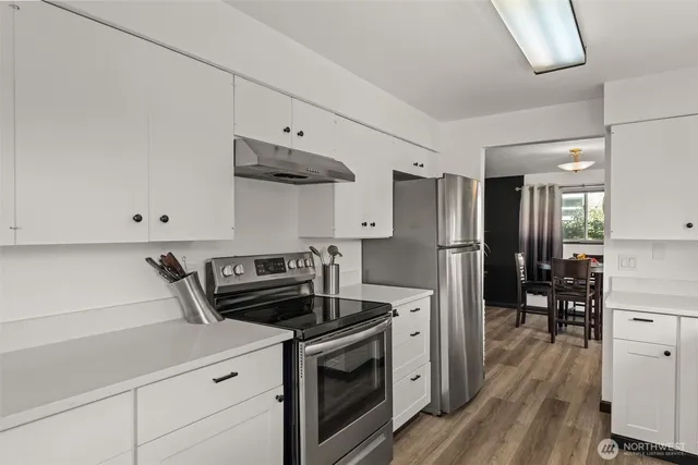 a kitchen with stainless steel appliances a sink a stove and cabinets