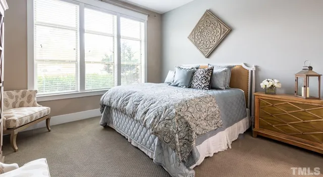 a large bed sitting in a bedroom next to a window