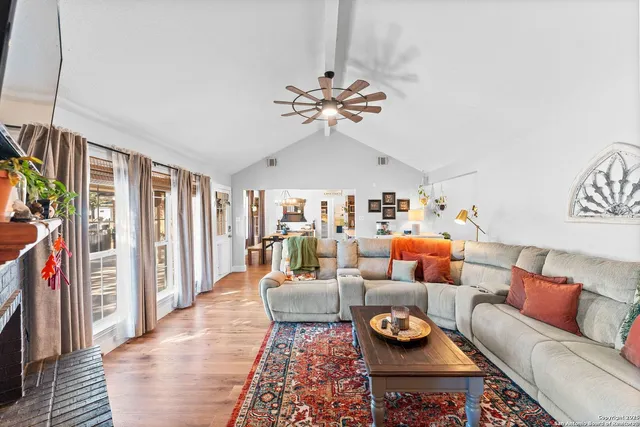 a living room with furniture a flat screen tv and a fireplace