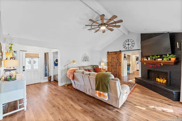 a living room with a bed furniture and a flat screen tv