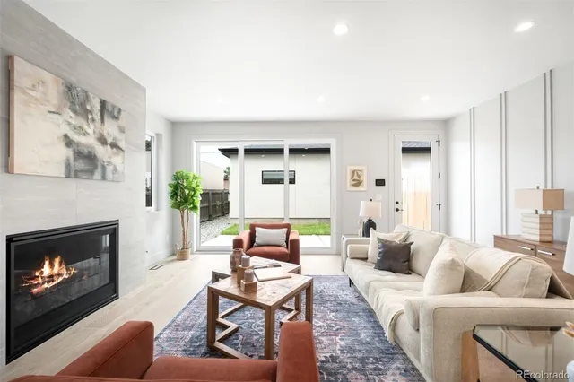 a living room with furniture a fireplace and a large window