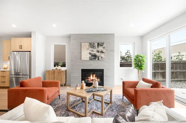 a living room with furniture fireplace and a large window