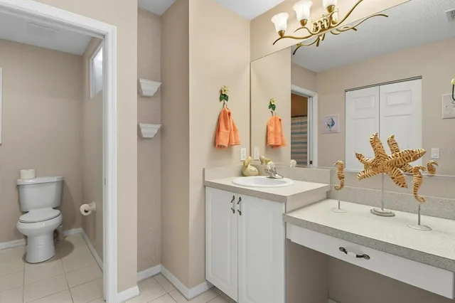 a bathroom with a sink a toilet and large mirror