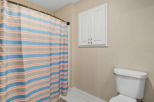 a bathroom with a toilet and a shower curtain