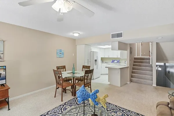 a kitchen with a dining table chairs and refrigerator