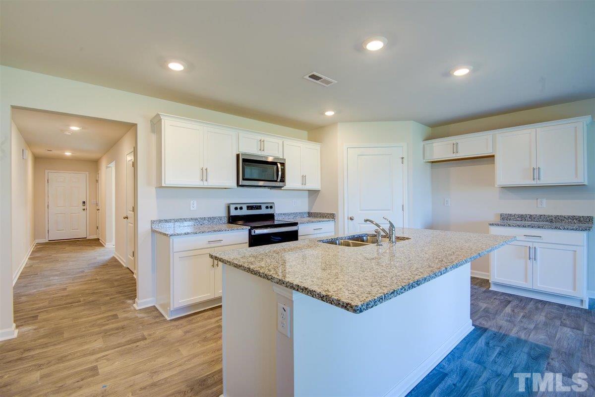 7653 Sand Pit Road Stantonsburg, NC 27883 - Photo 16 of 28 a kitchen with granite countertop a sink stove and refrigerator