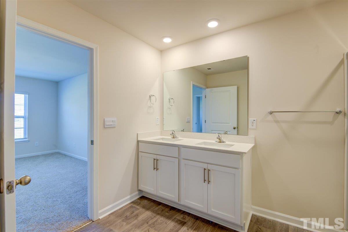 7653 Sand Pit Road Stantonsburg, NC 27883 - Photo 28 of 28 a bathroom with a double vanity sink and mirror