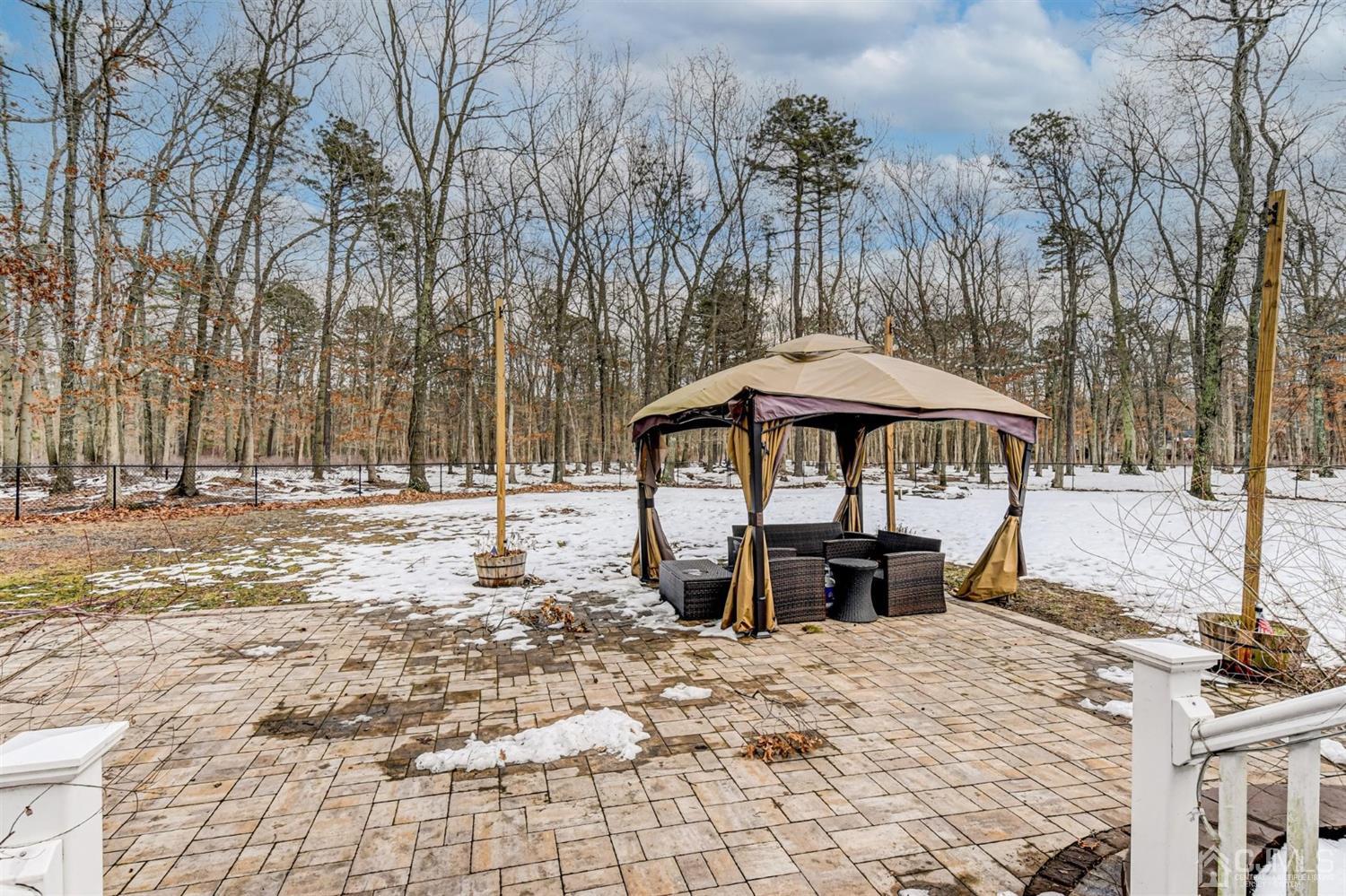 365 Cedar Swamp Road Jackson, NJ 08527 - Photo 30 of 38 a patio with a table and chairs under an umbrella
