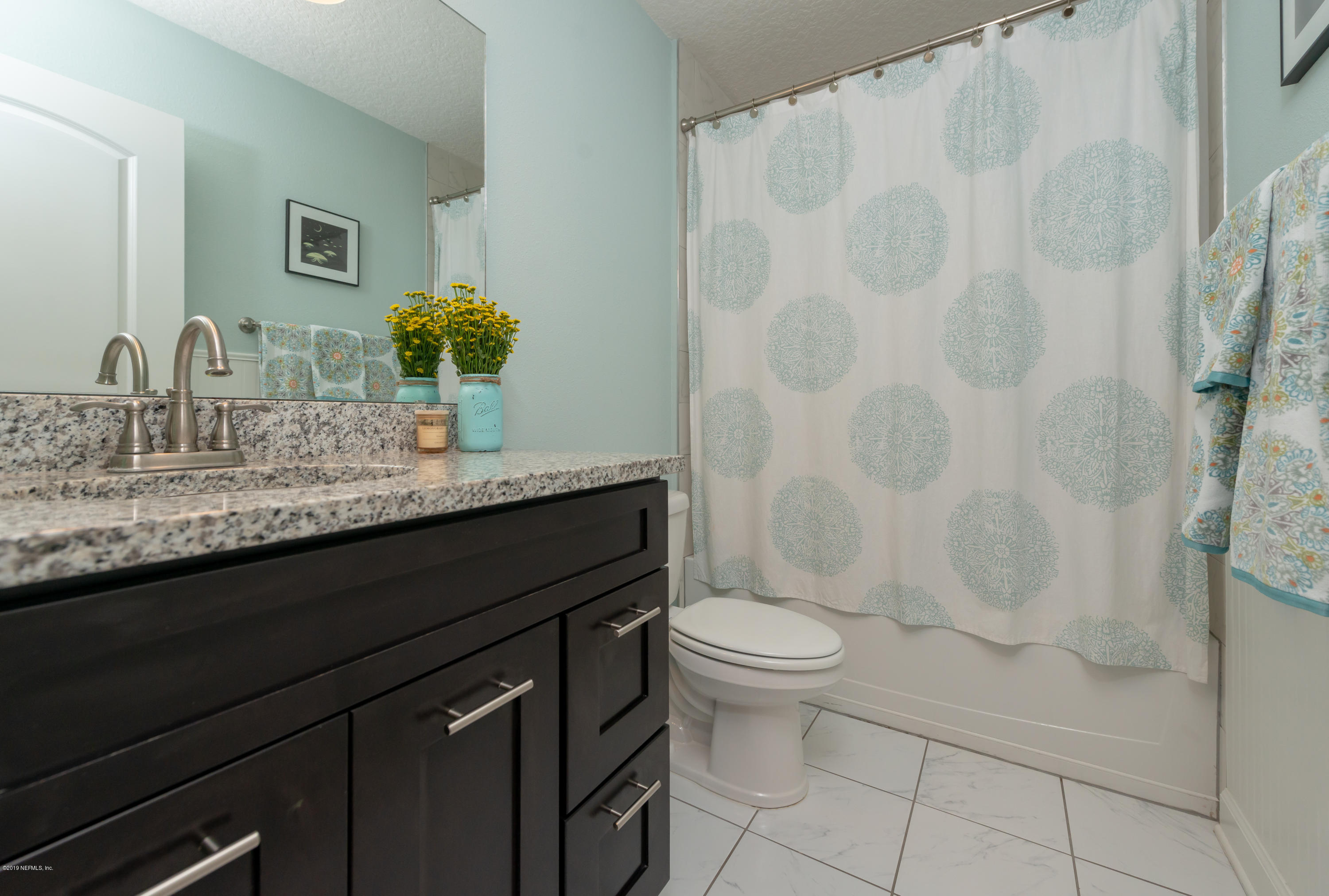 824 Queen Road St. Augustine, FL 32086 - Photo 23 of 35 a bathroom with a granite countertop sink a toilet and a mirror