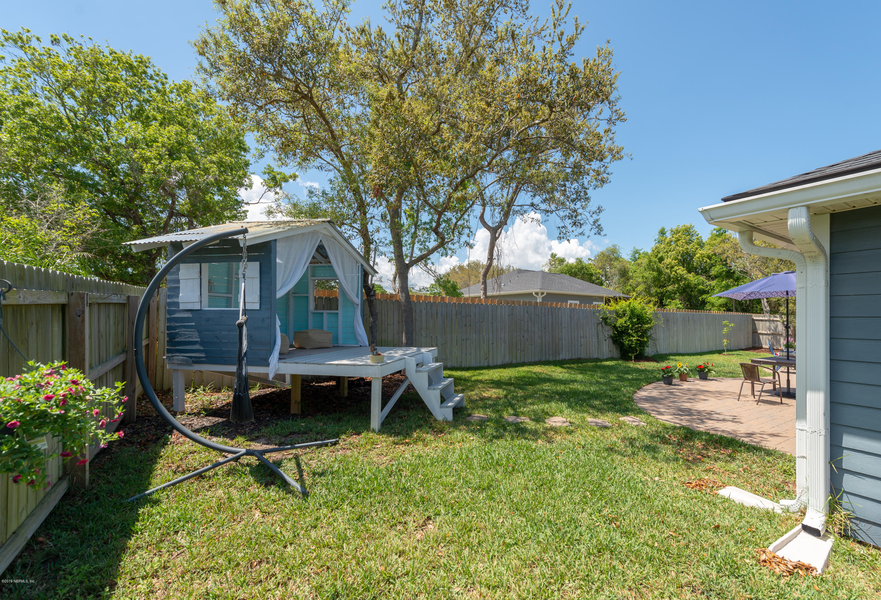 824 Queen Road St. Augustine, FL 32086 - Photo 33 of 35 a backyard of a house with table and chairs plants and large tree