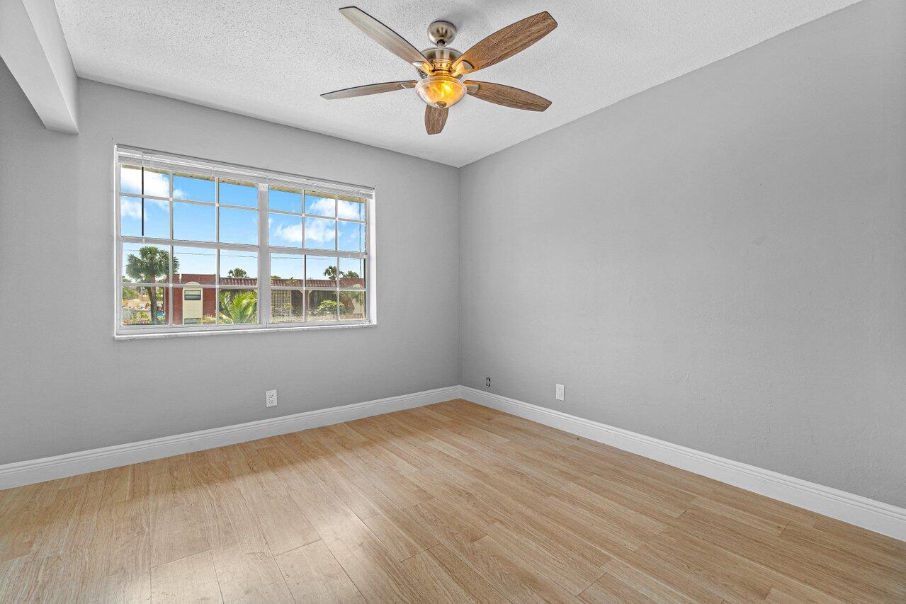 299 Southwest 7th Street, Unit 2060 Boca Raton, FL 33432 - Photo 12 of 20 an empty room with windows and fan