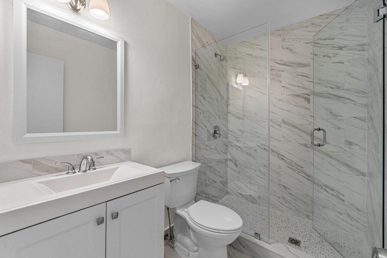 299 Southwest 7th Street, Unit 2060 Boca Raton, FL 33432 - Photo 13 of 20 a bathroom with a sink a toilet and shower