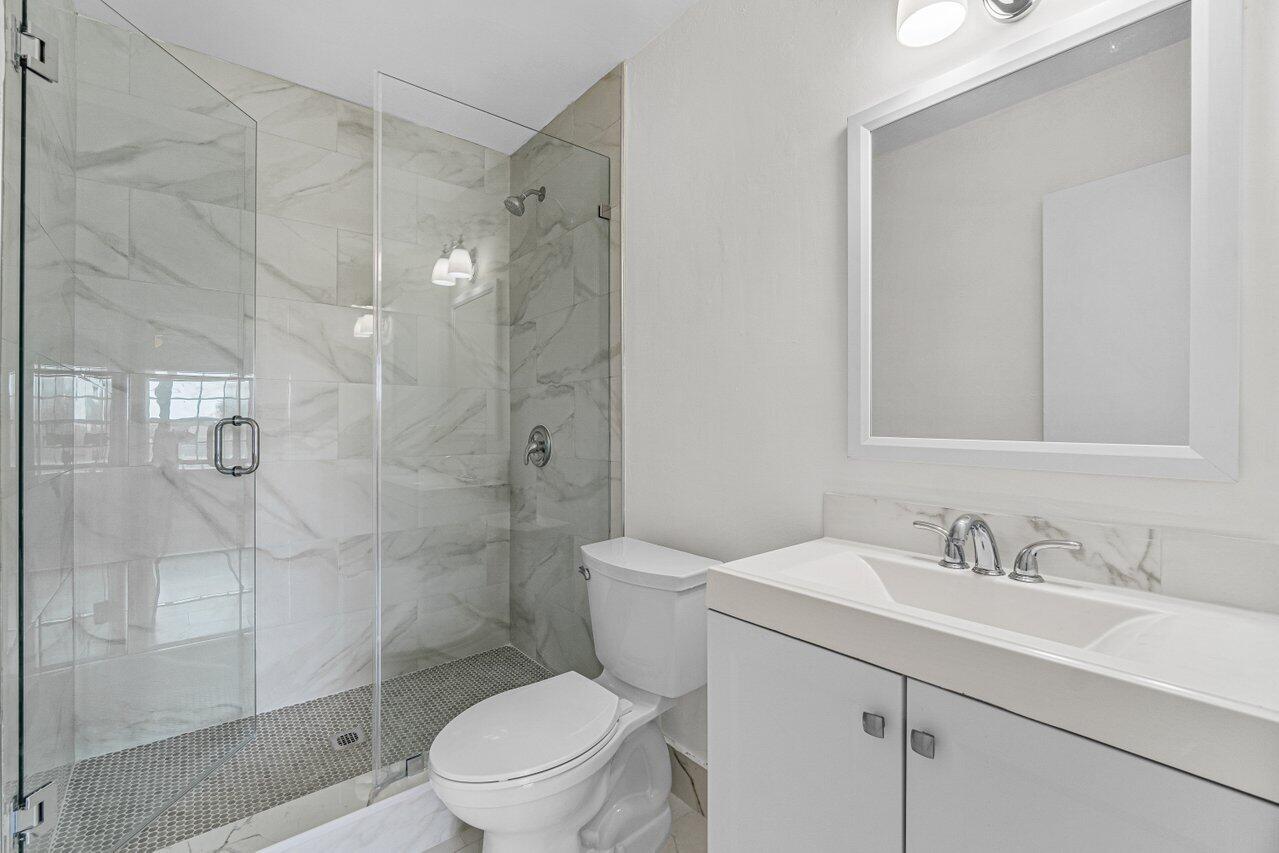 299 Southwest 7th Street, Unit 2060 Boca Raton, FL 33432 - Photo 17 of 20 a bathroom with a sink toilet and shower