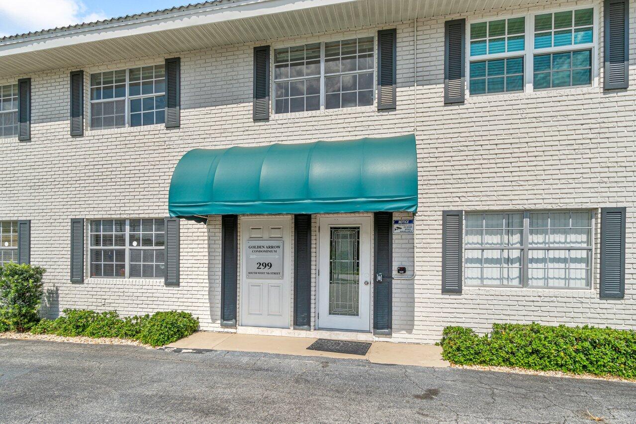 299 Southwest 7th Street, Unit 2060 Boca Raton, FL 33432 - Photo 3 of 20 a front view of a house with a yard and potted plants