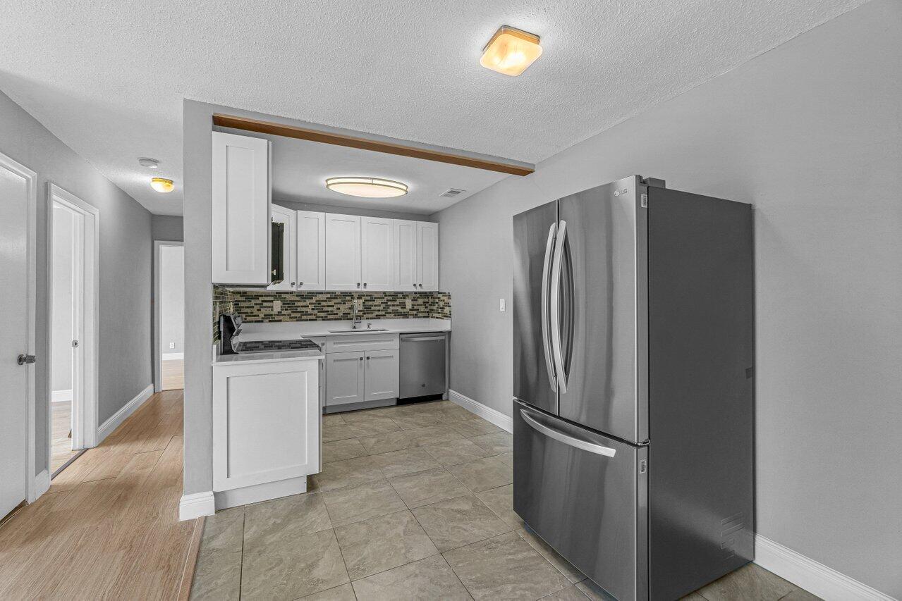 299 Southwest 7th Street, Unit 2060 Boca Raton, FL 33432 - Photo 4 of 20 a kitchen with stainless steel appliances a refrigerator sink and stove