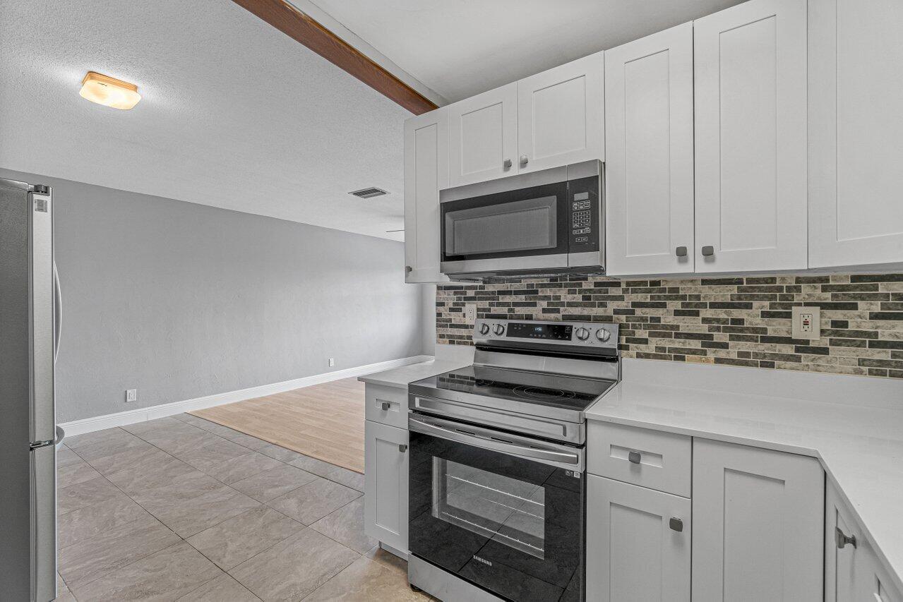 299 Southwest 7th Street, Unit 2060 Boca Raton, FL 33432 - Photo 6 of 20 a kitchen with cabinets stainless steel appliances and a counter space