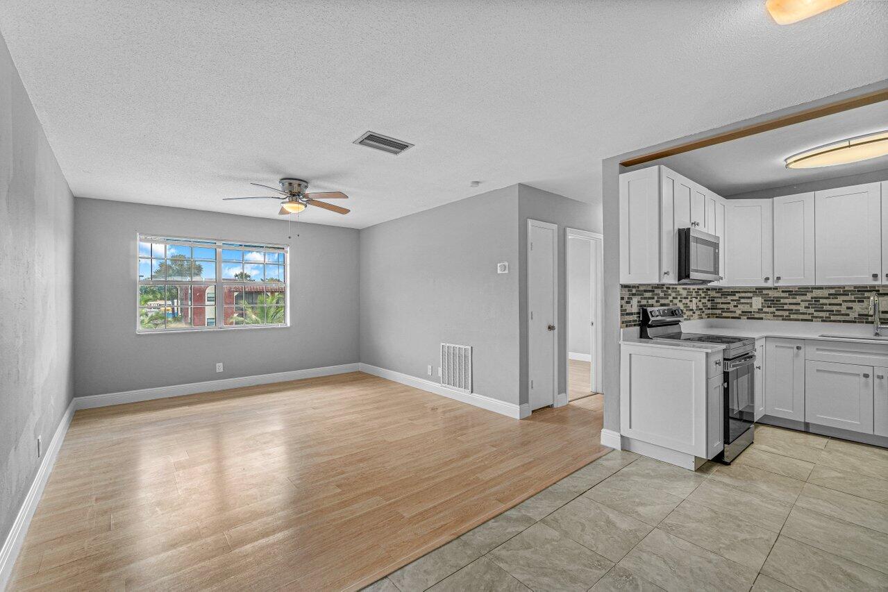 299 Southwest 7th Street, Unit 2060 Boca Raton, FL 33432 - Photo 8 of 20 a view of kitchen with granite countertop cabinets and window