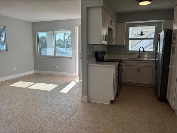 a kitchen with stainless steel appliances a stove a sink a refrigerator a window