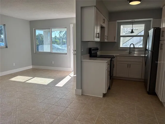 a kitchen with stainless steel appliances a stove a sink a refrigerator a window