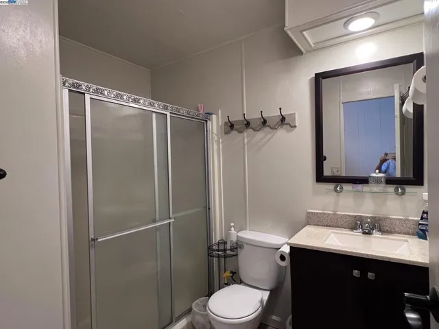 a bathroom with a toilet sink vanity and mirror