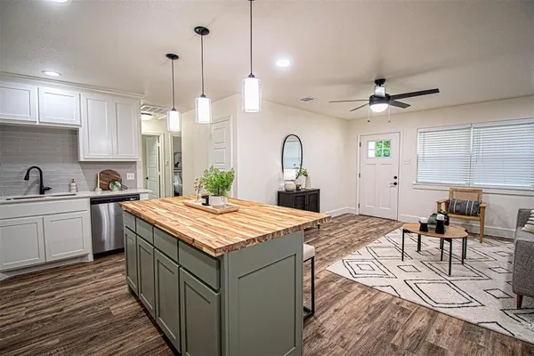 a kitchen with stainless steel appliances kitchen island granite countertop a sink a stove and a refrigerator
