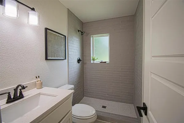 a bathroom with a sink a toilet and shower